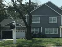 a house with gray siding and a mailbox in the front yard